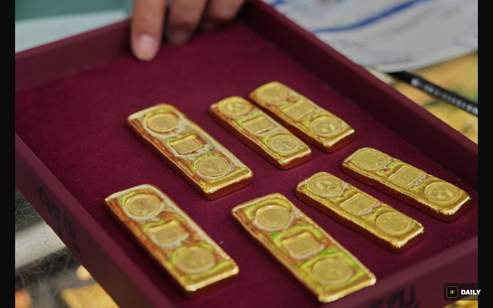 Small gold bullion bars displayed in a velvet-lined tray