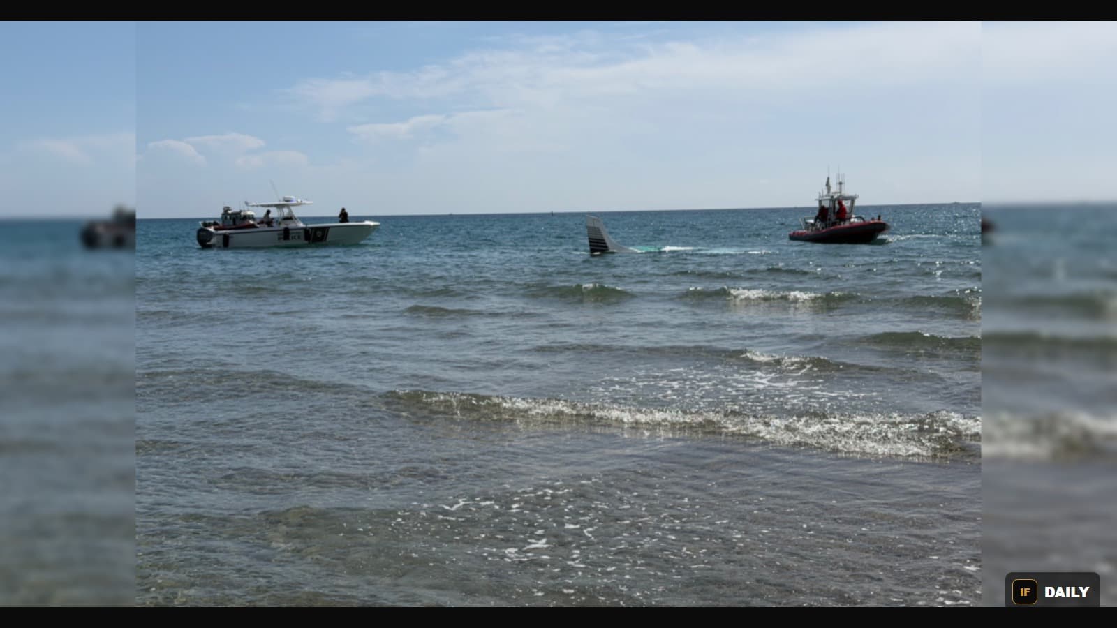 Rescue boats approaching the tail of a small plane submerged in the ocean off Boca Raton, Florida
