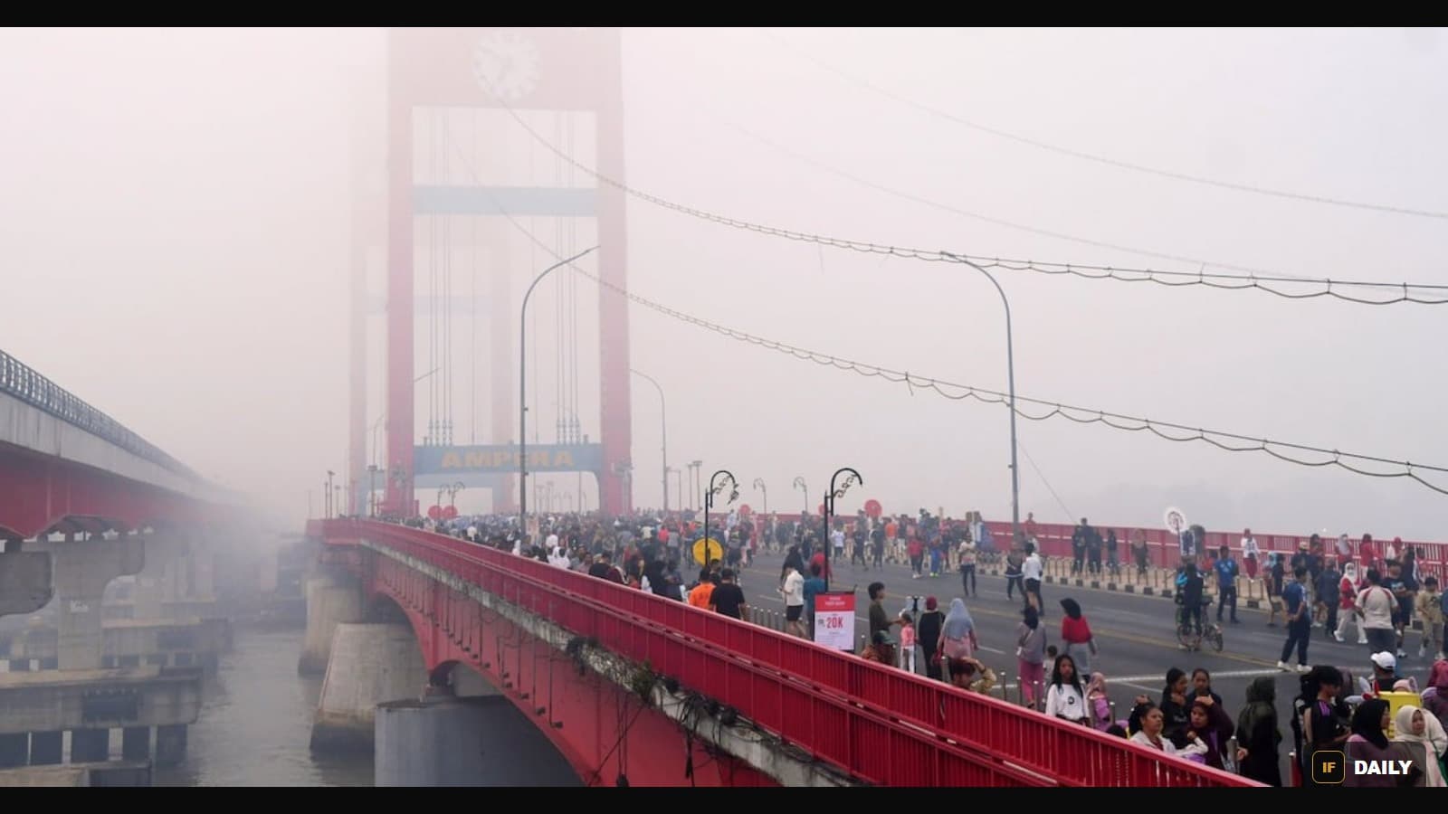 The Ampera Bridge in Palembang, Indonesia, shrouded in thick wildfire haze as crowds cross it