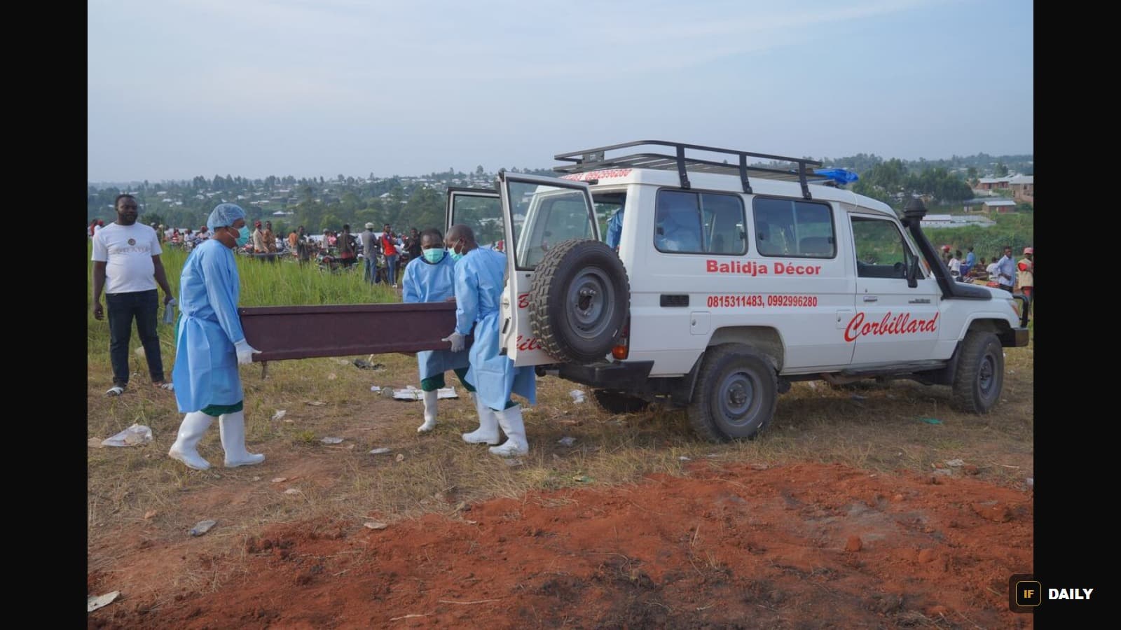 Health workers in protective gear carrying a coffin toward a hearse marked "Corbillard" in eastern Congo