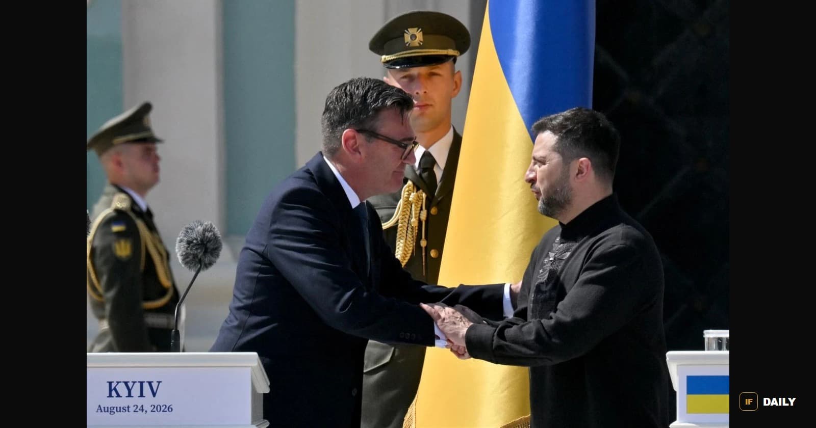 Andy Burnham and Volodymyr Zelenskyy shaking hands in Kyiv in front of a large Ukrainian flag, with a nameplate reading Kyiv, August 24, 2026