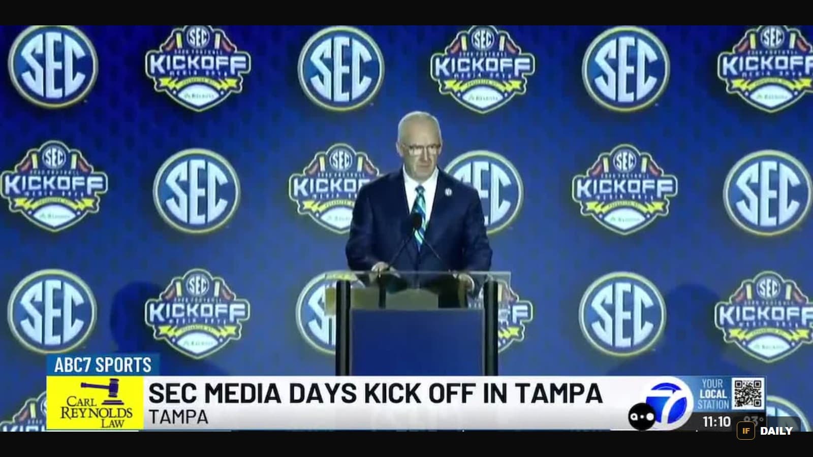 SEC Commissioner Greg Sankey speaking at a podium in front of a wall of SEC and SEC Kickoff Media Days logos