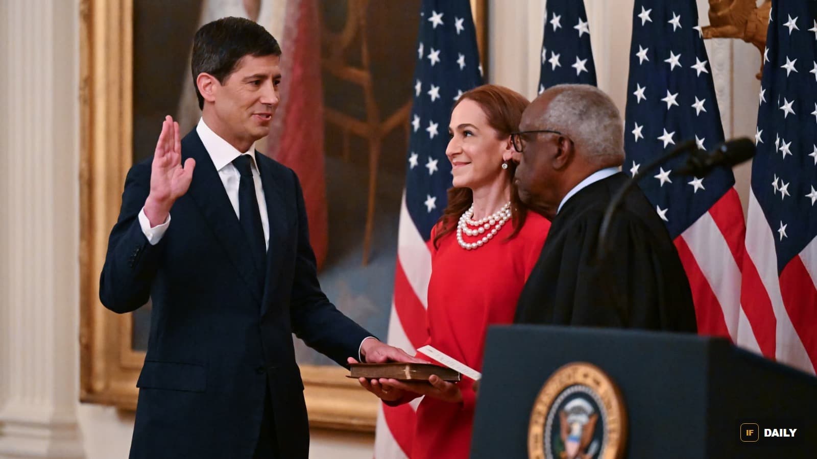 Kevin Warsh being sworn in as Federal Reserve Chair, raising his hand with his wife holding a Bible and a Supreme Court justice administering the oath