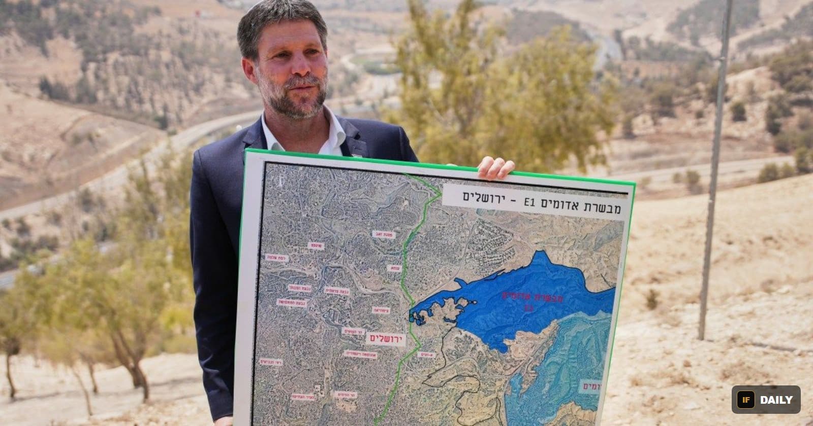 Israeli Finance Minister Bezalel Smotrich holding a map labeled with the E1 settlement development area near Jerusalem