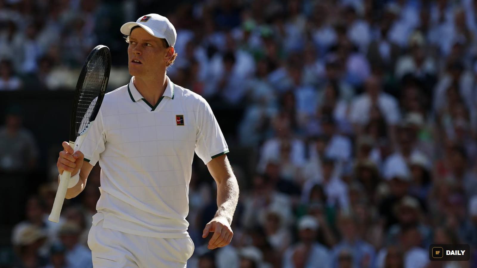 Jannik Sinner holding his racket and looking upward during a match at Wimbledon