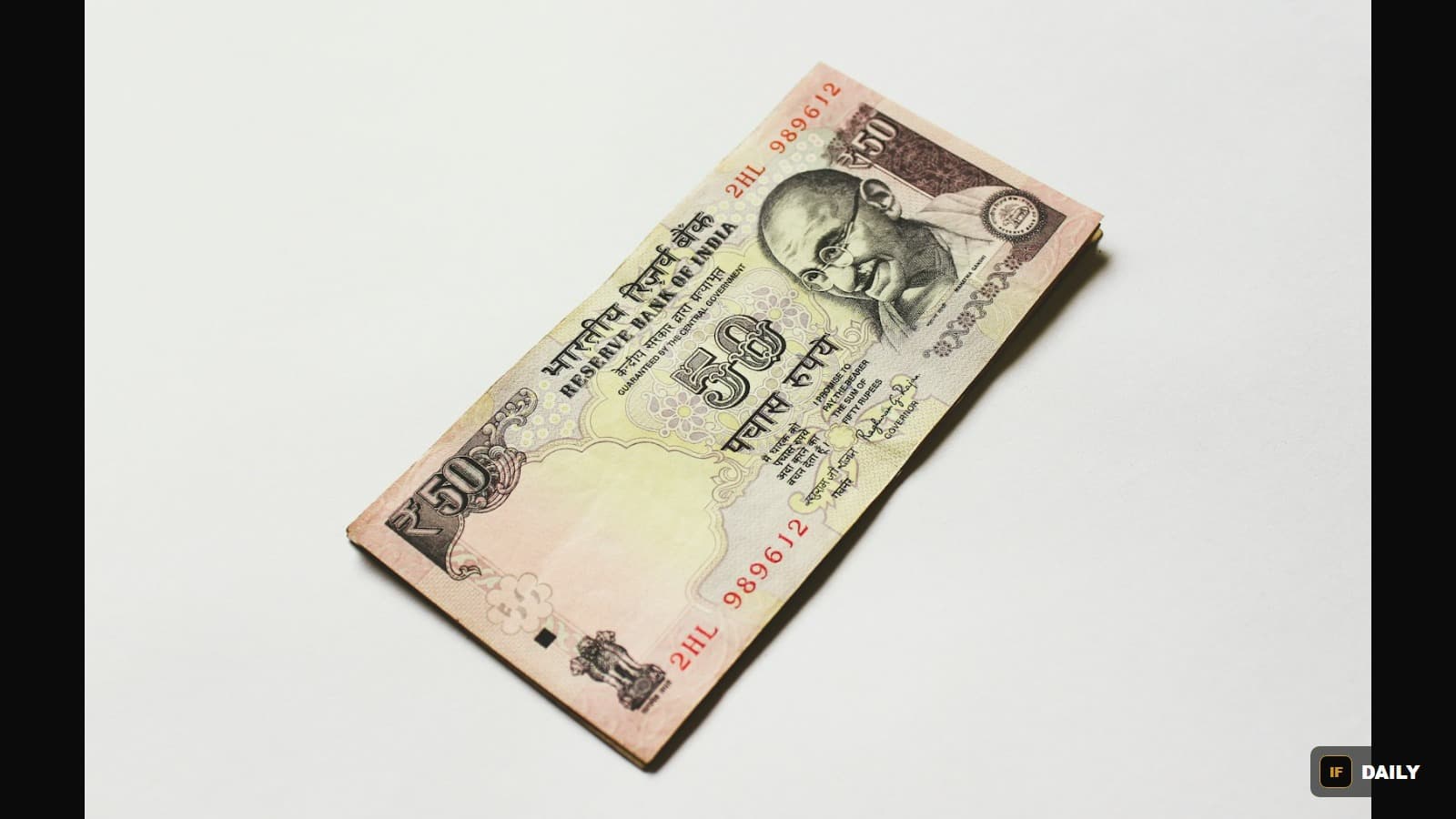 A folded 50 Indian rupee banknote photographed on a plain white background