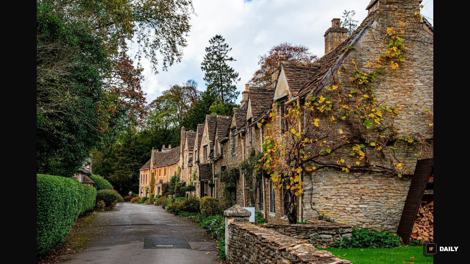 A row of honey-colored stone cottages along a quiet street in a Cotswolds village