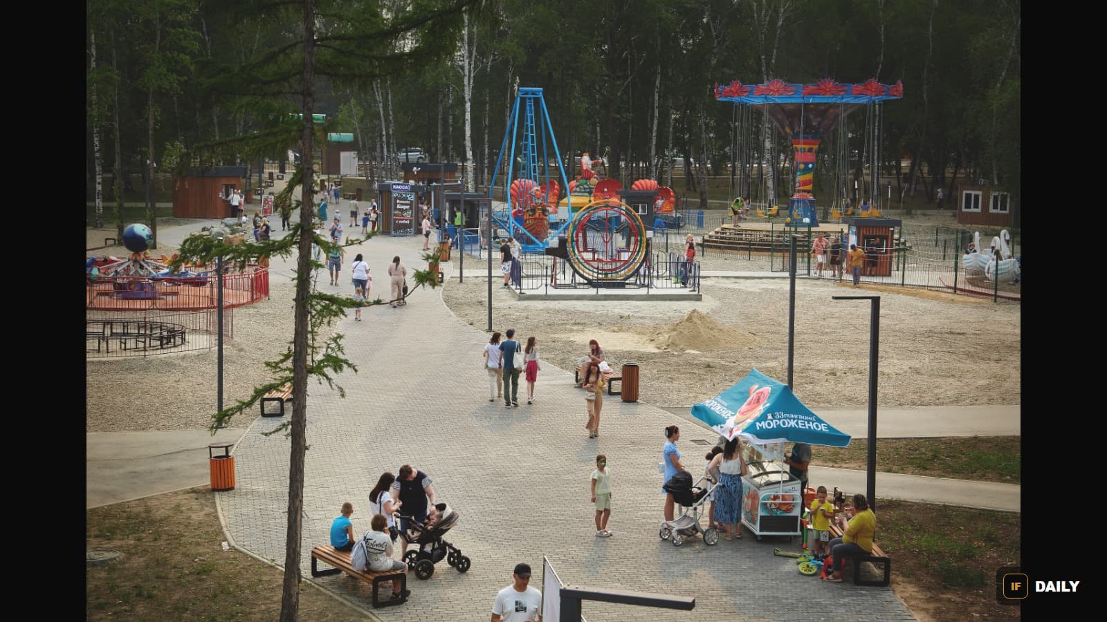 A park in Svobodny, Amur Oblast, Russia, with visitors walking near amusement rides