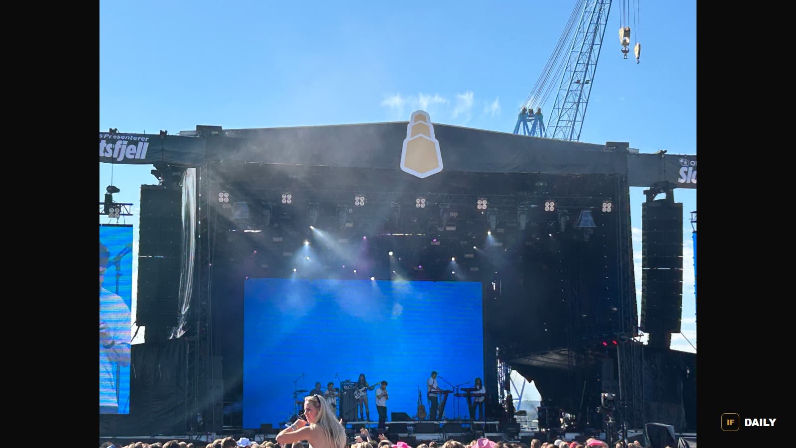 Alex Warren performing on a large outdoor festival stage in daylight