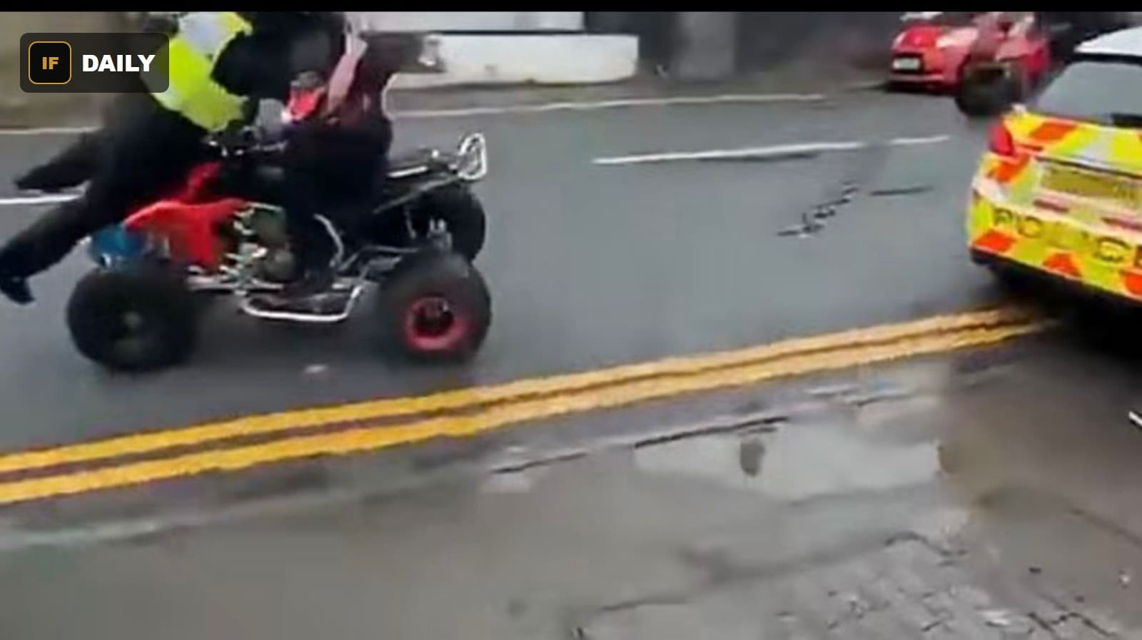 The quad bike passes within inches of the rear of the marked police car
