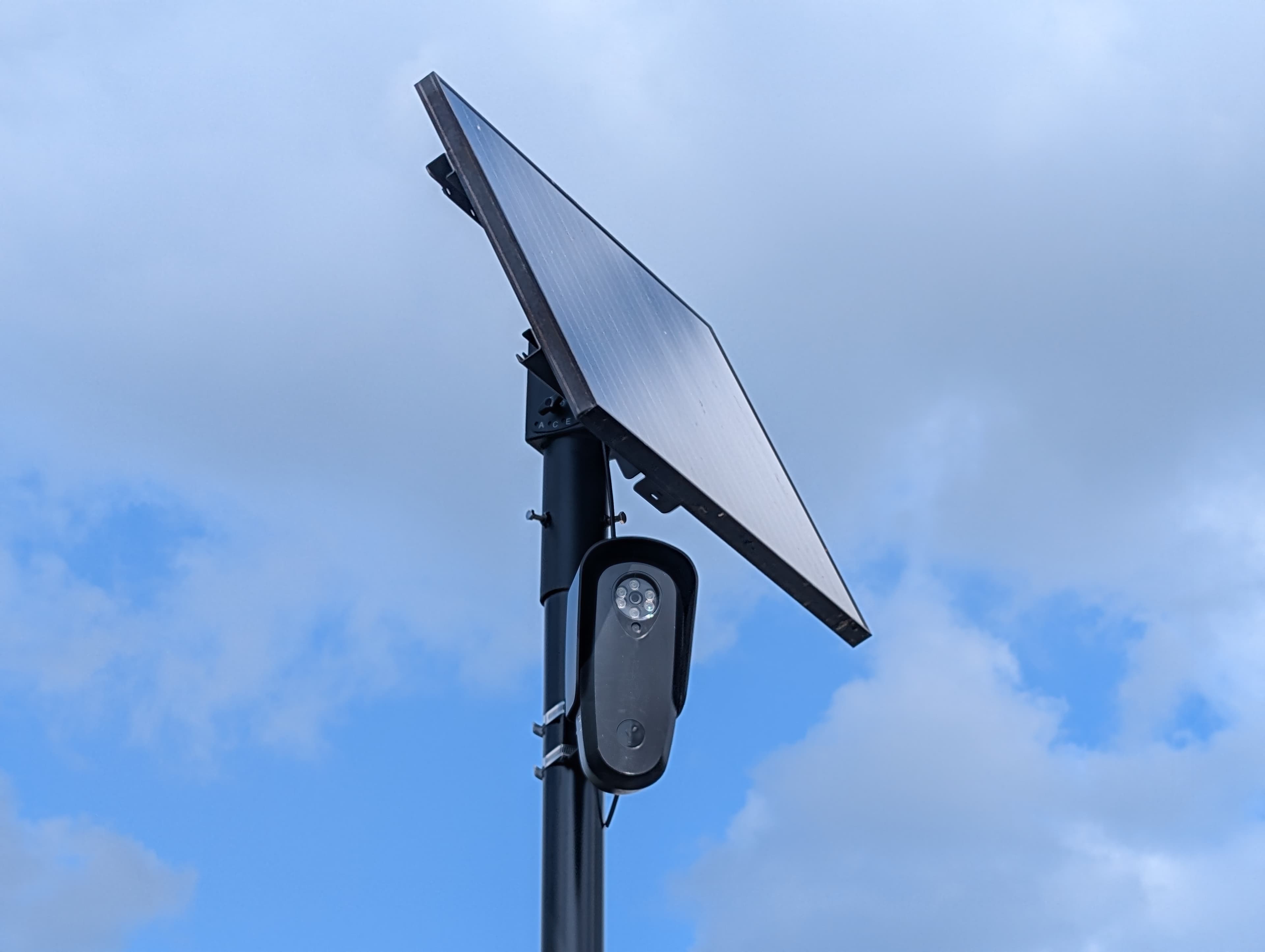 A Flock Safety automated license plate reader camera mounted on a pole with a solar panel