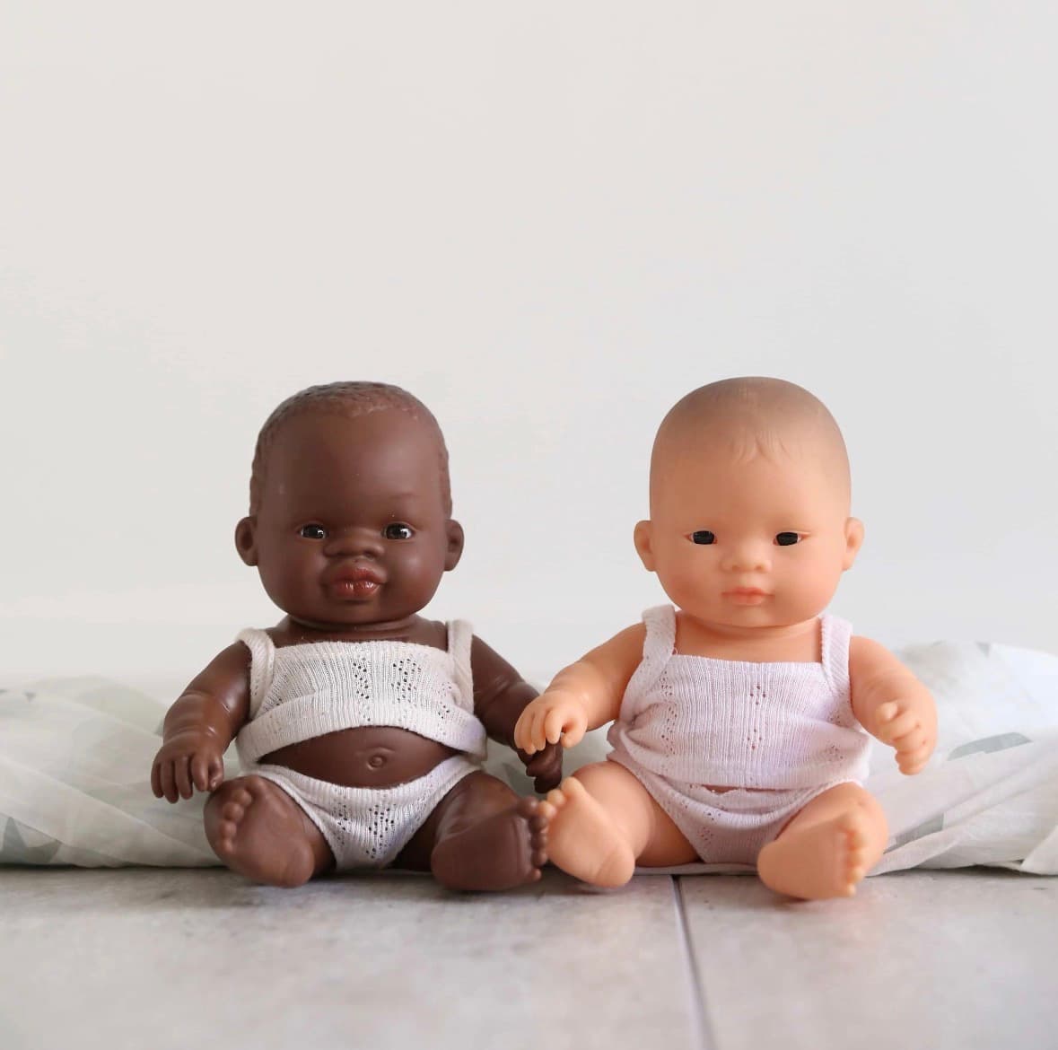 Miniland baby dolls representing African, brown and white skin tones