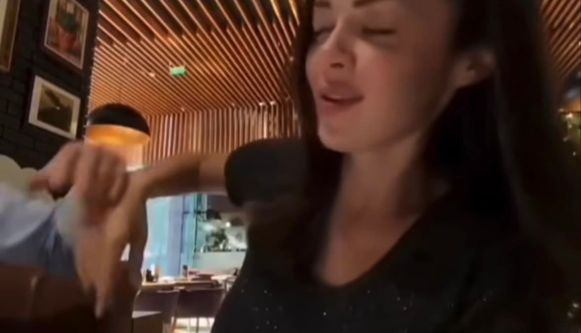 Blurred video from viral Threads post showing woman in restaurant during moment described as not playful