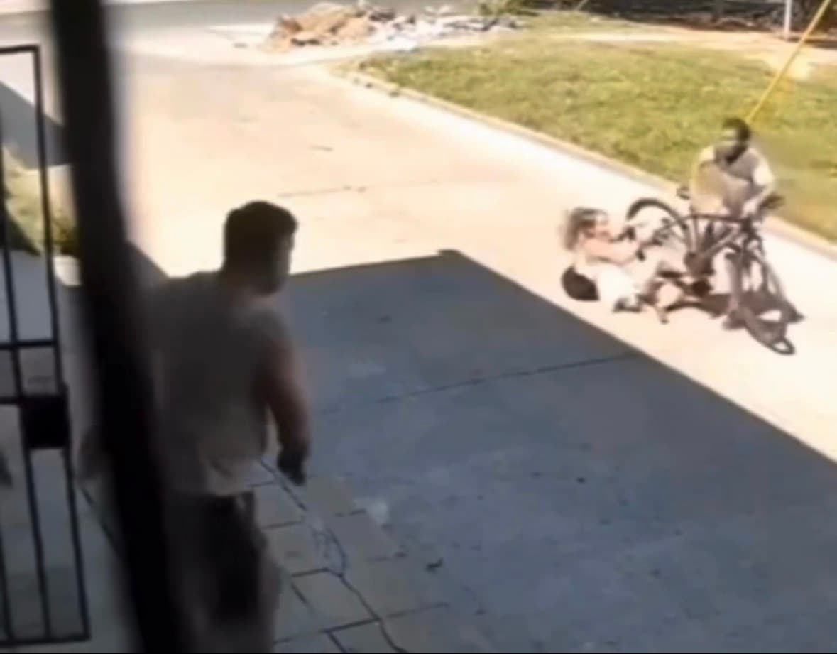 Teenage girl on bicycle in residential street, faces blurred, from viral video of attempted theft