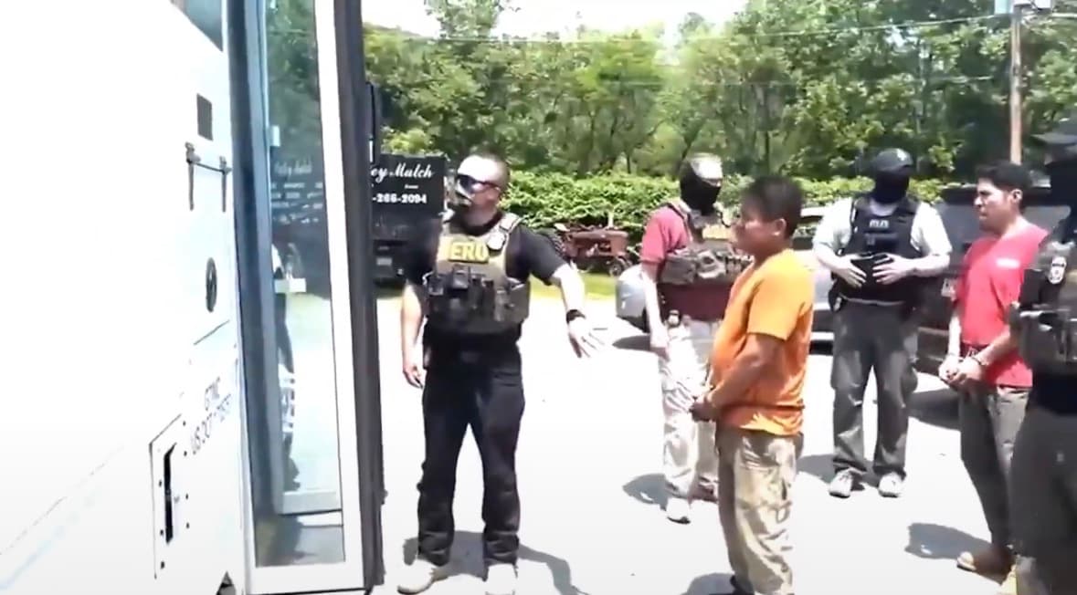 Agents in ERO vests standing near white bus in video circulating as Philadelphia ICE worksite raid