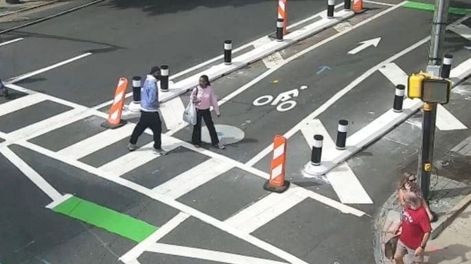 Surveillance footage shows a robbery suspect following a woman through an Atlanta crosswalk before an alleged attack.