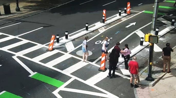 Surveillance footage shows a robbery suspect following a woman through an Atlanta crosswalk before an alleged attack.