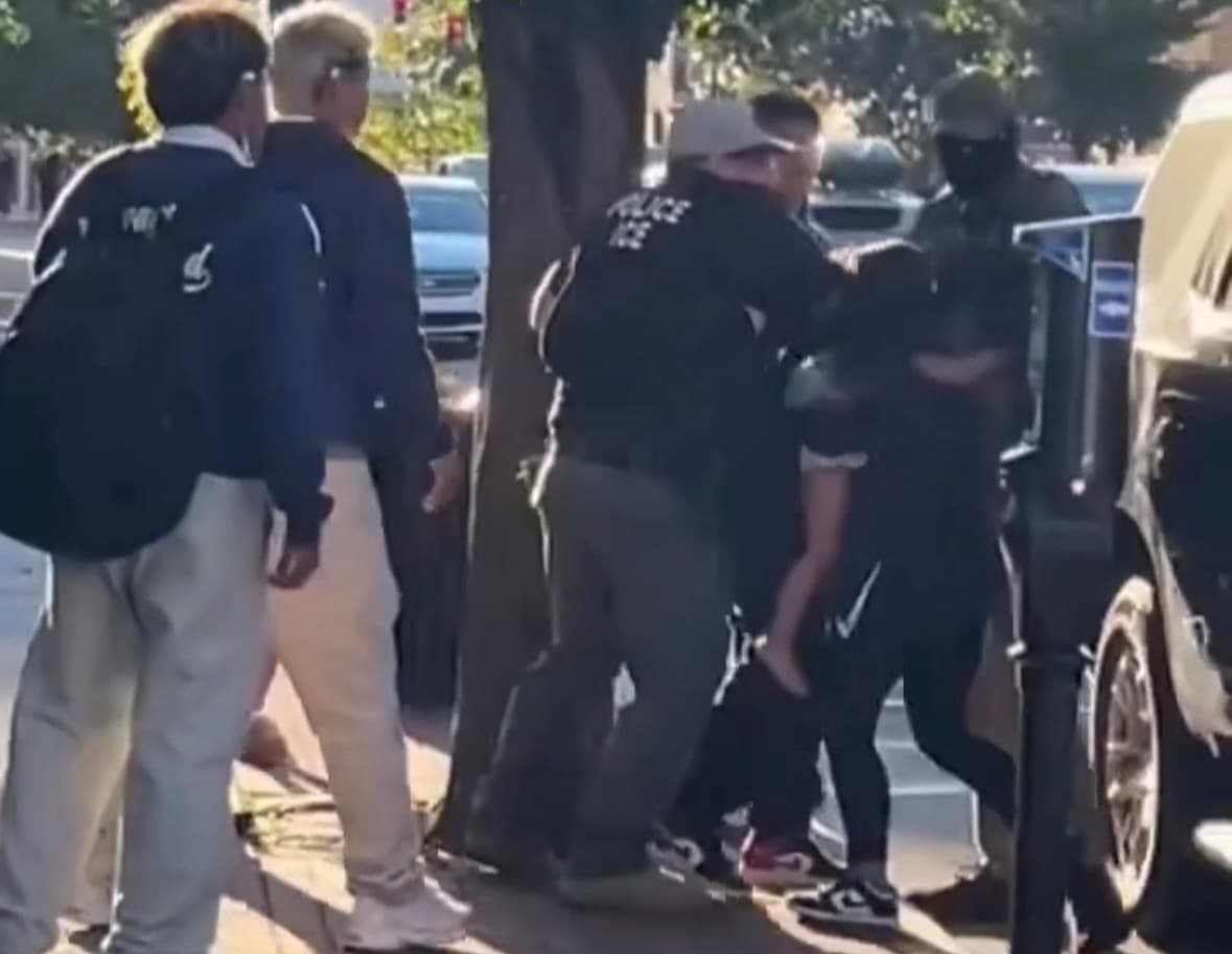 ICE agents detain a man beside an SUV during an encounter in Harrison, New Jersey