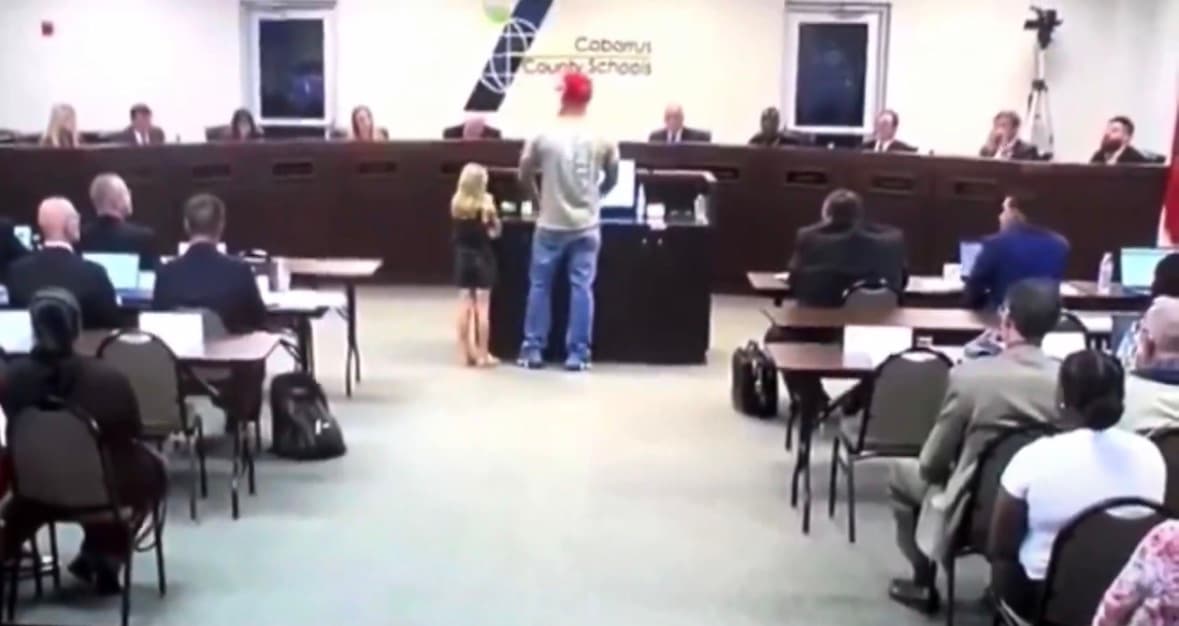 A father stands beside his young daughter while addressing the Cabarrus County Board of Education.